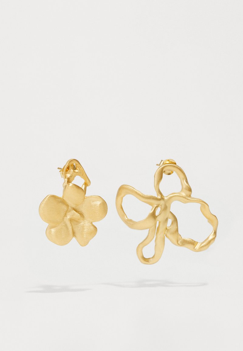 Χρυσά σκουλαρίκια με δύο σχέδια: ένα υφασμένο λουλούδι με στρογγυλεμένα πέταλα και μια ρευστή, αφηρημένη μορφή πεταλούδας. Και τα δύο διαθέτουν ματ φινίρισμα.