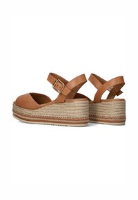 Sandali wedge in pelle marrone chiaro con cinturino regolabile, dotati di una soletta in giute intrecciato e suola testurizzata, forma curva e design aperto nella parte anteriore.