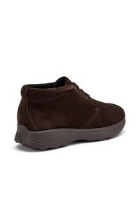 Scarpa ankle in suede marrone scuro con lacci, colletto imbottito e suola spessa e testurizzata, mostrata da un angolo laterale su sfondo bianco.
