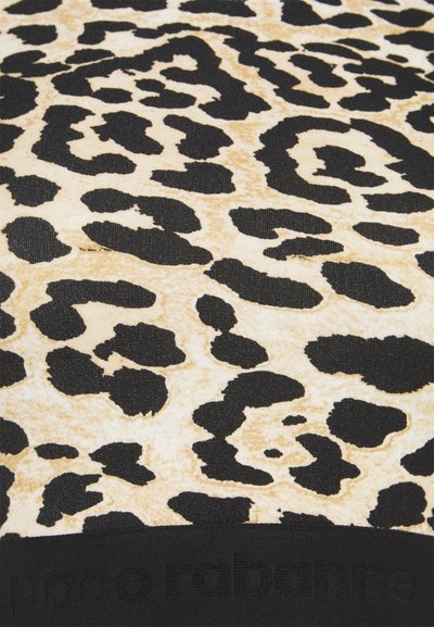 O tecido de estampa de leopardo apresenta um fundo castanho claro com grandes manchas pretas. Uma faixa preta na parte inferior contém letras em relevo.