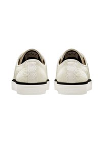 Zapatillas blancas con un upper texturizado y un diseño de perfil bajo. Presentan una suela blanca y acentos negros en el talón. Vista trasera.