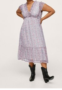 Kukallinen mekko, jossa on V-pääntie, lyhyet röyhelöhihoja ja kerroksellinen helma. Kangas on kevyt ja virtaava, jossa on sinisiä ja vaaleanpunaisia kuvioita.