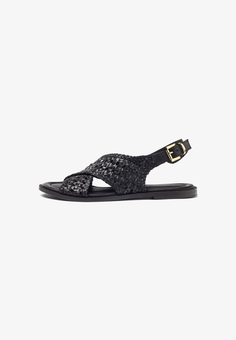 Zwarte gevlochten leren sandalen met kruislings gespen, een verstelbare enkelband met een gouden gesp, en een platte zool.