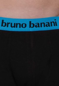 Svarta underkläder med ett turkosa midjeband som har texten "bruno banani" i svarta bokstäver. Mjuk tygkvalitet med en traditionell design.
