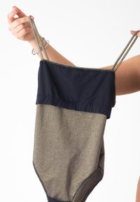 Maillot de bain or et bleu marine avec des fines bretelles. La partie supérieure est bleu marine, tandis que la partie inférieure est en tissu métallique texturé de couleur or.