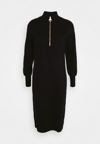 Zwarte midi-jurk met lange mouwen, hoge kraag en goudkleurige rits aan de voorkant, nauwsluitende manchetten en twee borstzakken met klep.