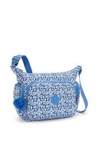 Blå mönstrad axelväska med en texturerad tyg, två dragkedjefack och en dekorativ blå pom-pom charm.