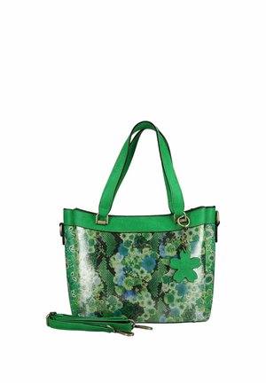 Zelená kabelka s květinovým vzorem, dvěma rukojeti, odnímatelným ramenním popruhem a přívěskem ve tvaru čtyřlístku zavěšeným vpředu.