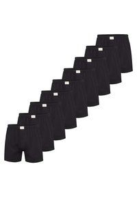 Černé bavlněné boxerky s elastickým pasem, se zapínáním na knoflíky, uspořádané v řadě, ukazující více kusů.