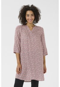 Tunique rouge et blanche avec un motif en zigzag, manches trois-quarts, décolleté en V et un détail de bouton au niveau du cou. Tissu doux, coupe décontractée.
