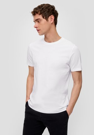 Weißes kurzärmliges T-Shirt mit rundem Halsausschnitt und glatter Textur, kombiniert mit dunklen Hosen, getragen von einer Person, die nach rechts schaut.