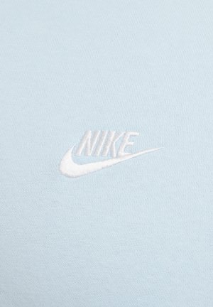 Light blue cotton fabric featuring an embroidered white Nike logo, showcasing a smooth texture and subtle design elements.