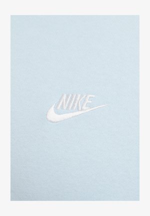 Heller blauer Baumwollstoff mit einem gestickten weißen Nike-Logo, das eine glatte Textur und subtile Designelemente zeigt.