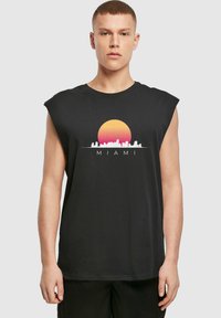 Tricou fără mâneci, de culoare neagră, cu un grafic al unui apus de soare și al orizontului, având textul "MIAMI". Este confecționat din bumbac, având o textură fină.