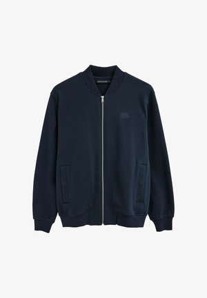 Marineblauwe bomberjack met ritssluiting, geribde kraag en manchetten, voorzakken en een klein "Polo Club"-logo op de borst.