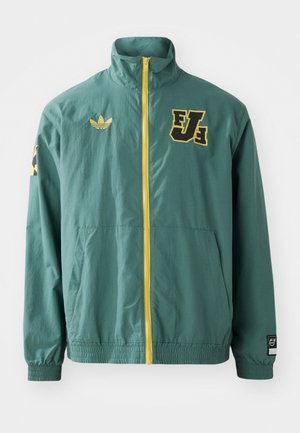 Green lightweight jacket featuring a yellow zipper, front pockets, and black/yellow logo accents on the collar and sleeve.