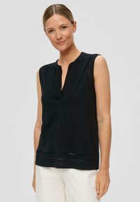 Black sleeveless top featuring a relaxed fit, v-neckline, and textured fabric with decorative stitching at the hem. Simple and versatile design.
