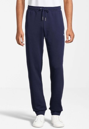 Pantaloni da jogging navy realizzati in tessuto morbido, dotati di una vita elastica con cordino, orli a costina e un piccolo logo sulla parte anteriore.