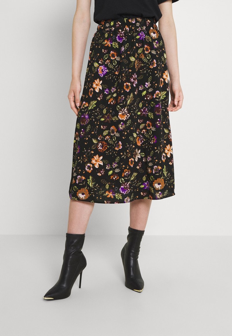 Black floral skirt with a relaxed fit, featuring colorful flower patterns, an elastic waistband, and a mid-length hem. Paired with black heeled boots.