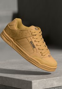 Yellow leather sneaker with padded collar, flat laces, textured surface, and "GLOBE" branding on the side. Rubber sole with grip patterns.