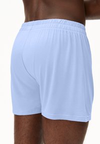 Himmelblaue Baumwollboxershorts mit elastischem Bund, glatter Textur und einem schlichten Design, das saubere, verarbeitete Nähte aufweist.