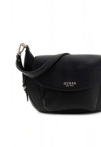 Sac bandoulière en cuir noir à surface texturée, rabat arrondi et détails de logo dorés. Bandoulière réglable incluse.