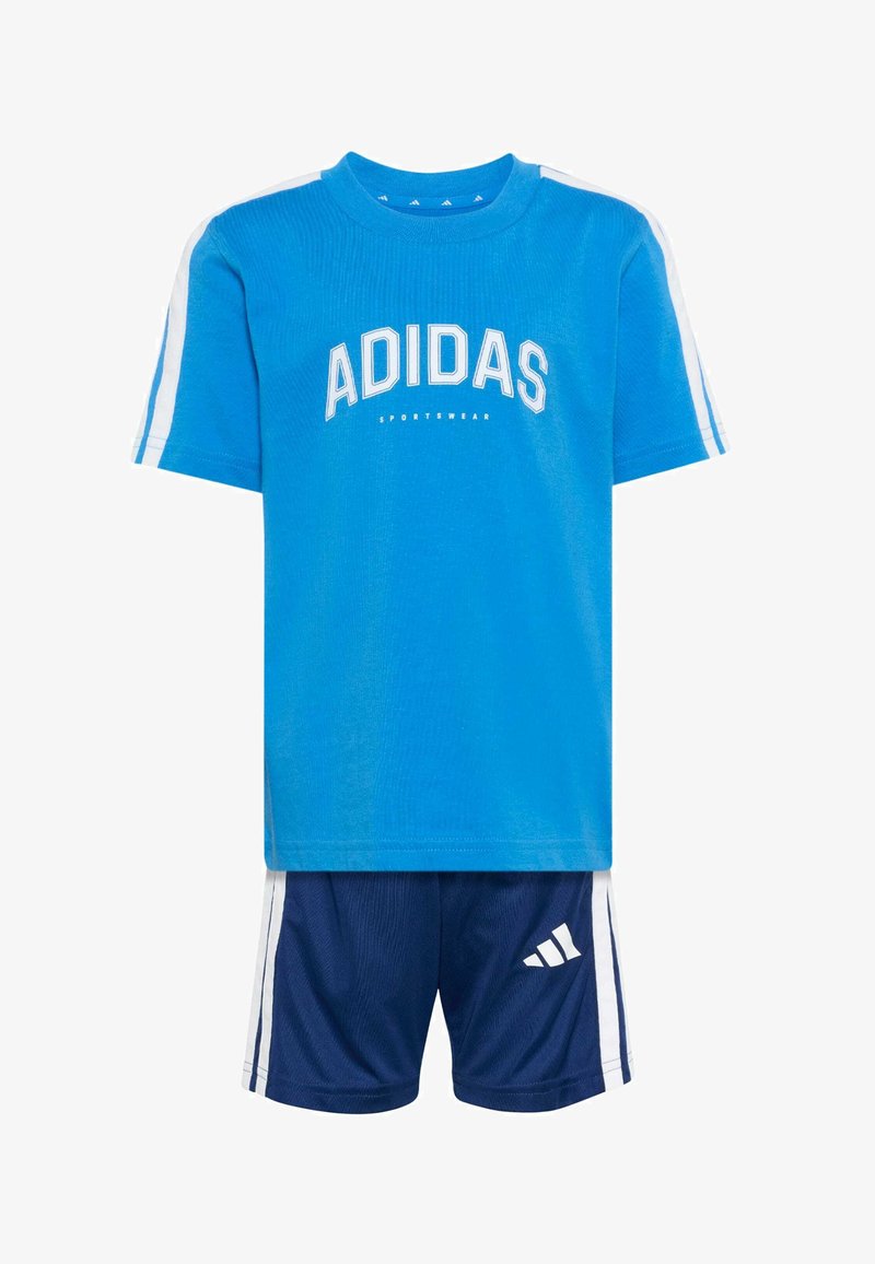 Plava pamučna majica s logom "ADIDAS", kratkih rukava s bijelim prugama; tamnoplave kratke hlače s bočnim prugama i detaljem loga.