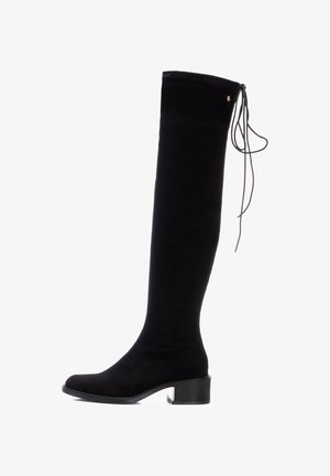 Botte noire over-the-knee en daim doux, avec un bout arrondi, un talon bloc et un détail de laçage décoratif en haut de la tige.