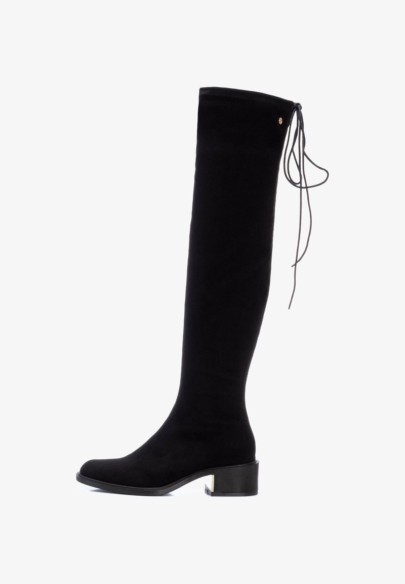 Botte noire over-the-knee en daim doux, avec un bout arrondi, un talon bloc et un détail de laçage décoratif en haut de la tige.