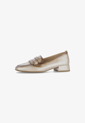 Beige laarzen van gepatenteerd leer met een lage blokhak en een decoratieve band over de voorkant, zijprofiel weergegeven op een witte achtergrond.