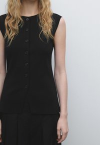 Zwart mouwloos topje met een ronde hals, voorzien van een knoopsluiting aan de voorkant en een aansluitend ontwerp, gemaakt van een soepele stof.