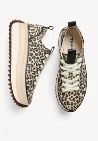 Sneaker con stampa leopardata in canvas texturizzato, lacci crema e una spessa suola piatta bianca con un motivo a zigzag nella parte inferiore.