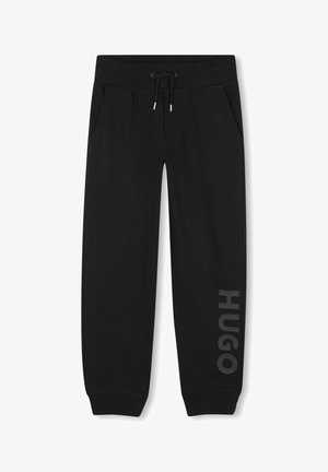 Zwarte joggingbroek van zacht materiaal, met zijzakken, een trekkoord in de tailleband, en "HUGO" in grijs gedrukt langs het linkerpoot.