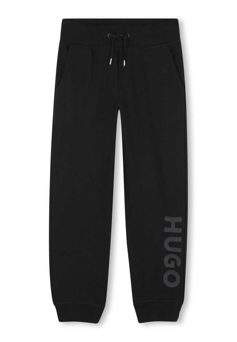 Zwarte joggingbroek van zacht materiaal, met zijzakken, een trekkoord in de tailleband, en "HUGO" in grijs gedrukt langs het linkerpoot.