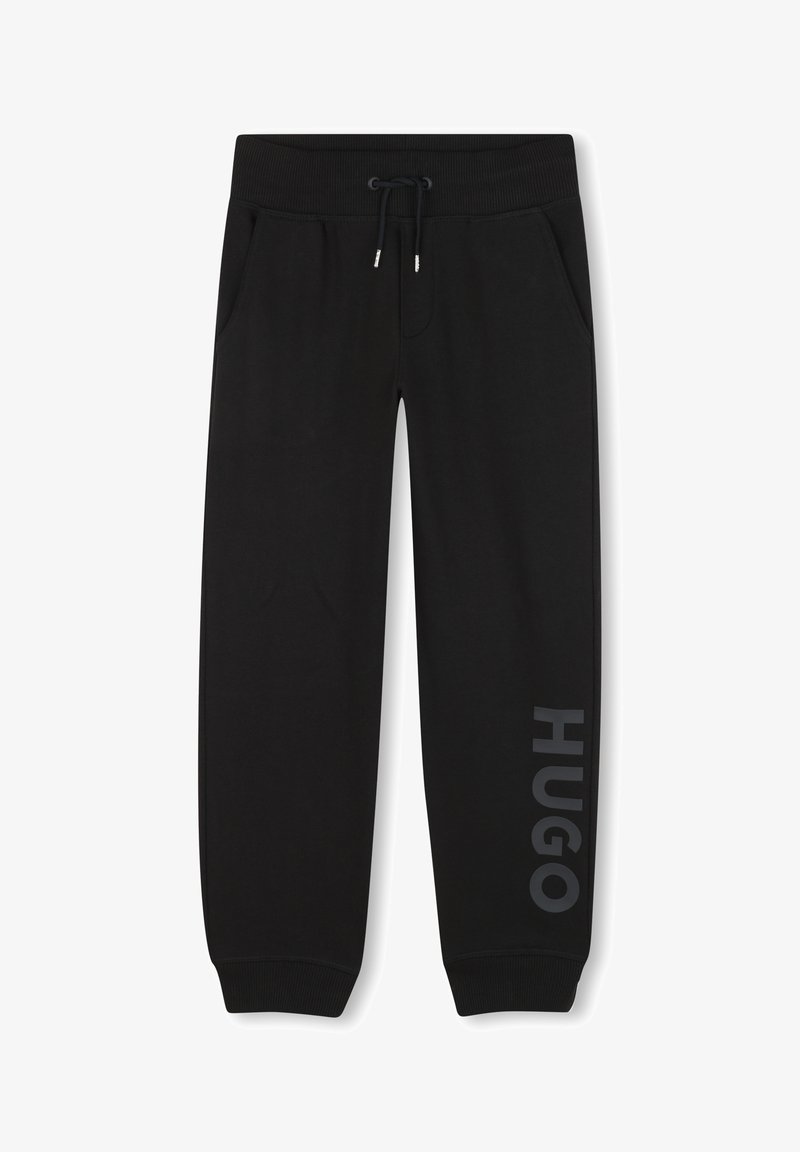 Zwarte joggingbroek van zacht materiaal, met zijzakken, een trekkoord in de tailleband, en "HUGO" in grijs gedrukt langs het linkerpoot.