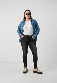 Világoskék farmering, fehér, testhez simuló póló, sötétszürke, skinny nadrág és törtfehér, kivágott részletekkel ellátott platform cipők.