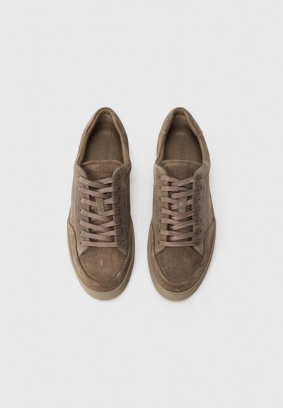 Pair of brown suede low-top sneakers with matching brown laces on a white background, viewed from above.