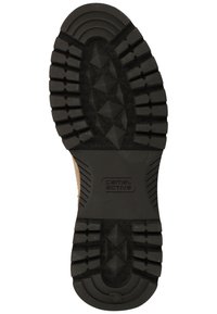 Black rubber shoe sole with deep tread pattern, featuring raised diamond-shaped accents and "camel active" logo near the heel.