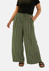 Gröna vida byxor med vertikala vita och svarta ränder, med elastisk midja och knytband, tillverkade av mjukt tyg.