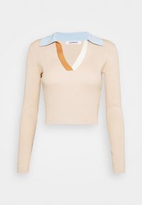Top de manga longa em bege com um comprimento cropped, apresentando um decote em V e uma gola multicolorida com detalhes em azul, branco e castanho.