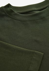 Donkergroene katoenen sweatshirt met een geribbelde ronde hals en textielstof. Zichtbare stikdetails langs de halslijn en manchetten.