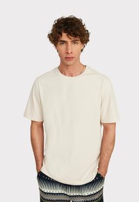 Off-white T-Shirt mit kurzen Ärmeln und Rundhalsausschnitt, aus weicher Baumwolle gefertigt. Verfügt über eine lockere Passform und eine glatte Textur. Keine sichtbaren Logos oder Muster.