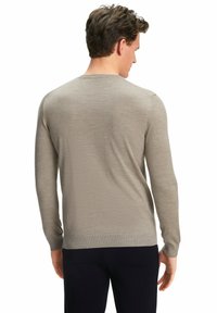 Beige langärmliger Pullover mit Rundhalsausschnitt, glatter Textur, slim-fit Design und gerippten Bündchen, kombiniert mit dunklen Hosen.