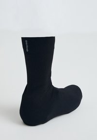 Črne nogavice do gležnja iz rebraste tkanine. Imajo logotip na strani, gladko teksturo in prilegajoč fit. Preprost dizajn, brez dodatnih vzorcev.
