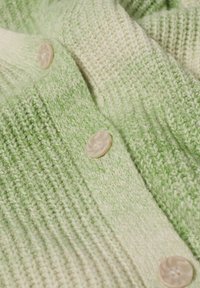 Cardigan en tricot aux nuances dégradées de vert avec un tissu texturé. Il présente des boutons ronds de couleur claire et une apparence douce et confortable.