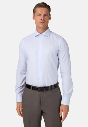 Lichtblauw gestreept overhemd met een puntkraag en knopenvoorkant, gecombineerd met donkergrijze broek en een zwarte riem.