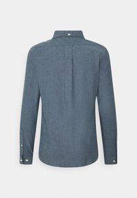 Chemise bleu-gris à manches longues boutonnée, vue de dos avec un pli au centre et des poignets boutonnés.