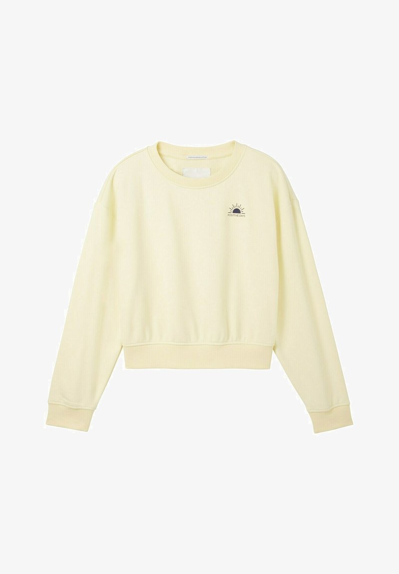 Sweat-shirt court jaune clair avec col rond, manches longues, et un motif graphique de soleil avec les mots « JOURS POSITIFS » en lettres foncées.