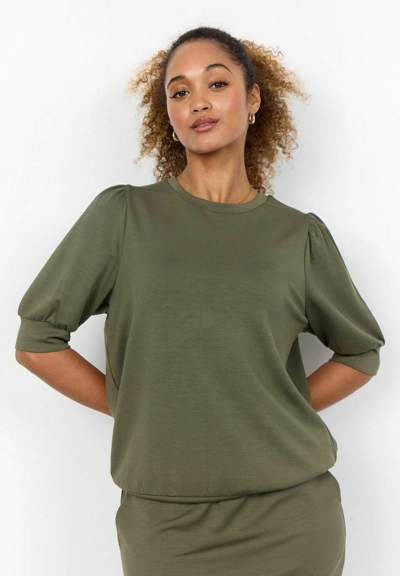 Blusa verde oliva con mangas cortas abullonadas y cuello redondo; confeccionada en una tela suave y ligera. Diseño sencillo y de corte relajado.