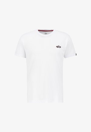 T-shirt en coton blanc à manches courtes avec un petit graphique d'étoile noire et rouge sur la poitrine gauche et un col intérieur rouge contrastant.